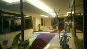 A modern hotel lobby with a reception desk, seating area, and a staircase leading to an upper floor. - Cankaya Konagi (Ankara)