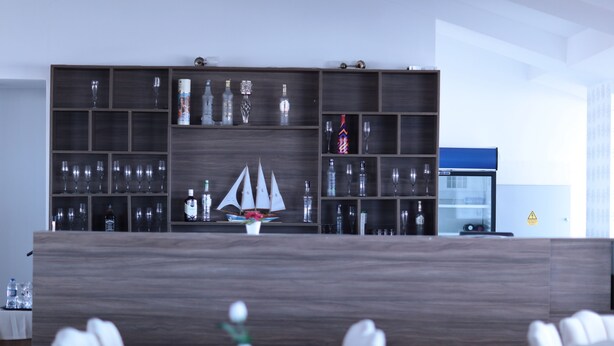 A modern hotel lobby with a wooden reception desk, a large ship model, and a refrigerator. - Cankaya Konagi (Ankara)