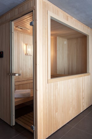Un sauna avec des murs en bois et un banc.