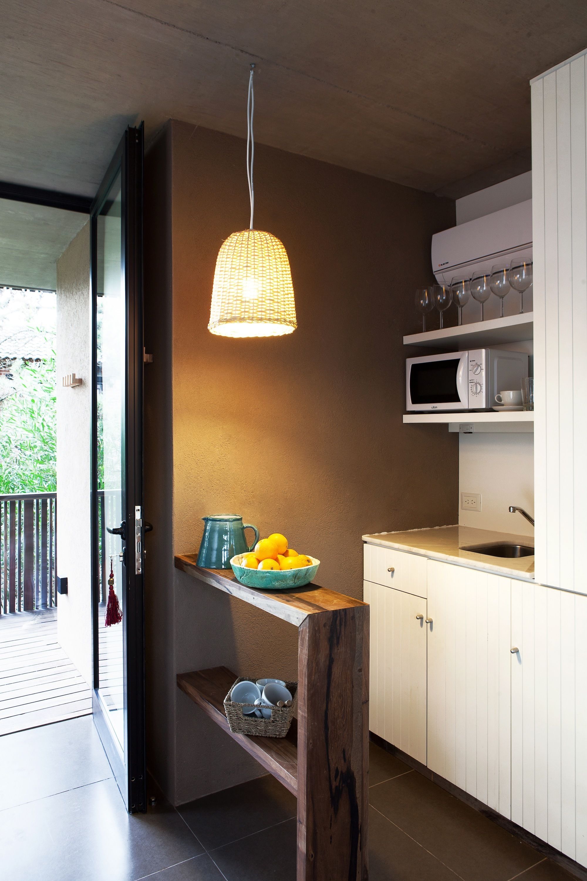 Una cocina moderna con armarios blancos, un microondas y un colgador de luces.