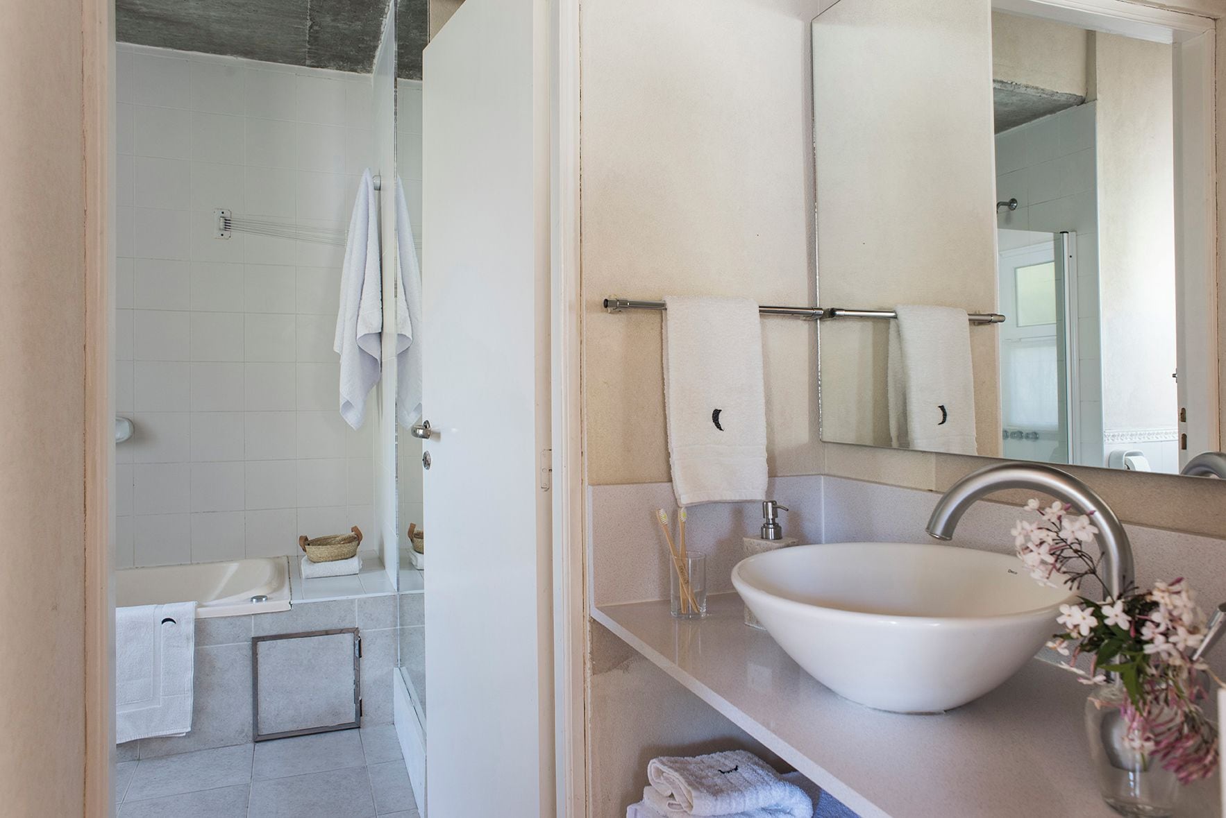 A modern bathroom with a bathtub, a large sink, and a mirror.