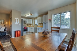 Enjoy meals in this well-equipped kitchen with a large dining table, oven, and stainless steel appliances.