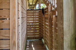 Un intérieur en bois avec un mur à lattes, une porte en métal et un plancher en bois.