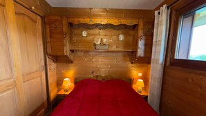 A wooden room with a bed, two bedside lamps, and a window. - Quiet 2-bedroom apartment, quick access to slopes, Les Saisies (Les Saisies)