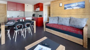 A compact living space with a kitchenette, dining area, and a sofa.