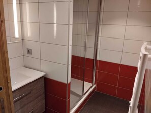 A bathroom with a white sink, a mirror, and a shower enclosure. - Bright renovated apartment - Near slopes, pets allowed (La Plagne Montchavin Les Coches)