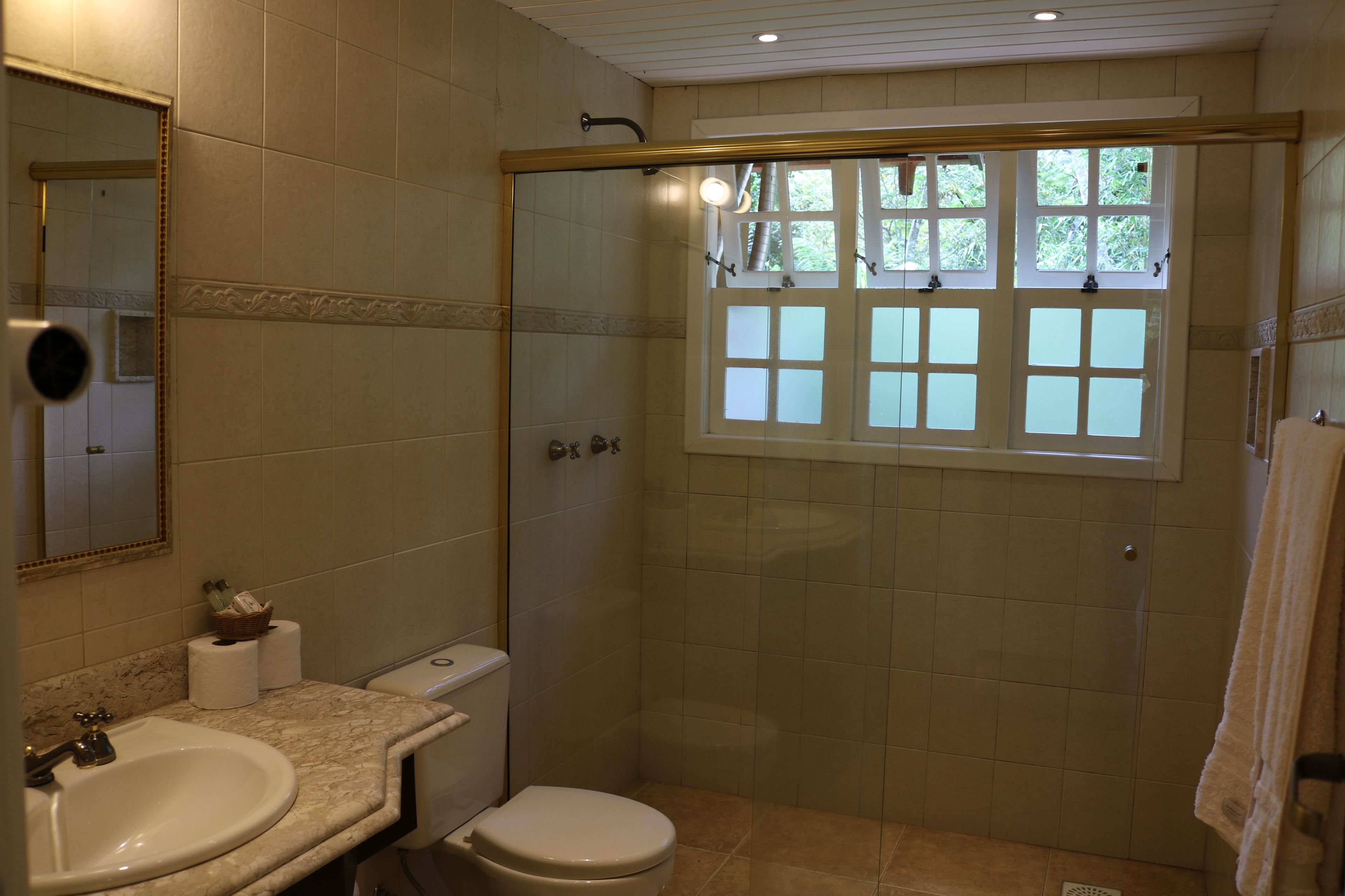 A bathroom with a sink, toilet, and shower area.