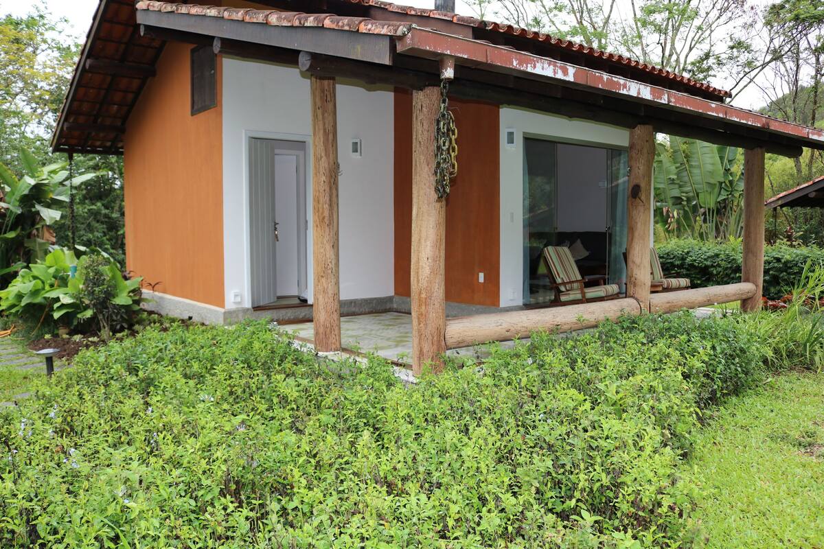 A small, single-story building with a wooden porch and a sliding glass door.
