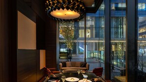 A dining area with a modern chandelier, a sofa, and a table set with various dishes.