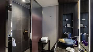 Bathroom features a glass-enclosed shower, large mirror, and vanity with a bowl sink.