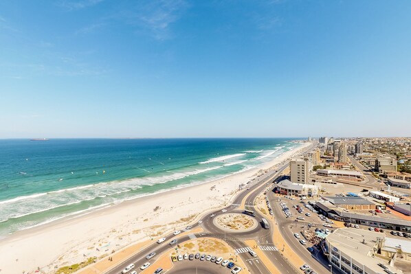 A coastal cityscape with a beach, roads, and buildings. - Horizon Bay 1602 (Cape Town)