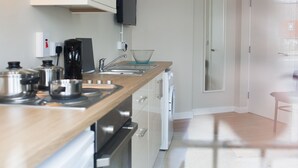 A modern kitchen with stainless steel appliances, a wooden countertop, and a built-in dishwasher.