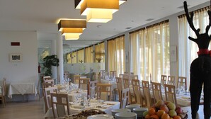 A dining area with tables set for service, a fruit basket, and a decorative ant sculpture. - Alpen Hotel Eghel (Folgaria)