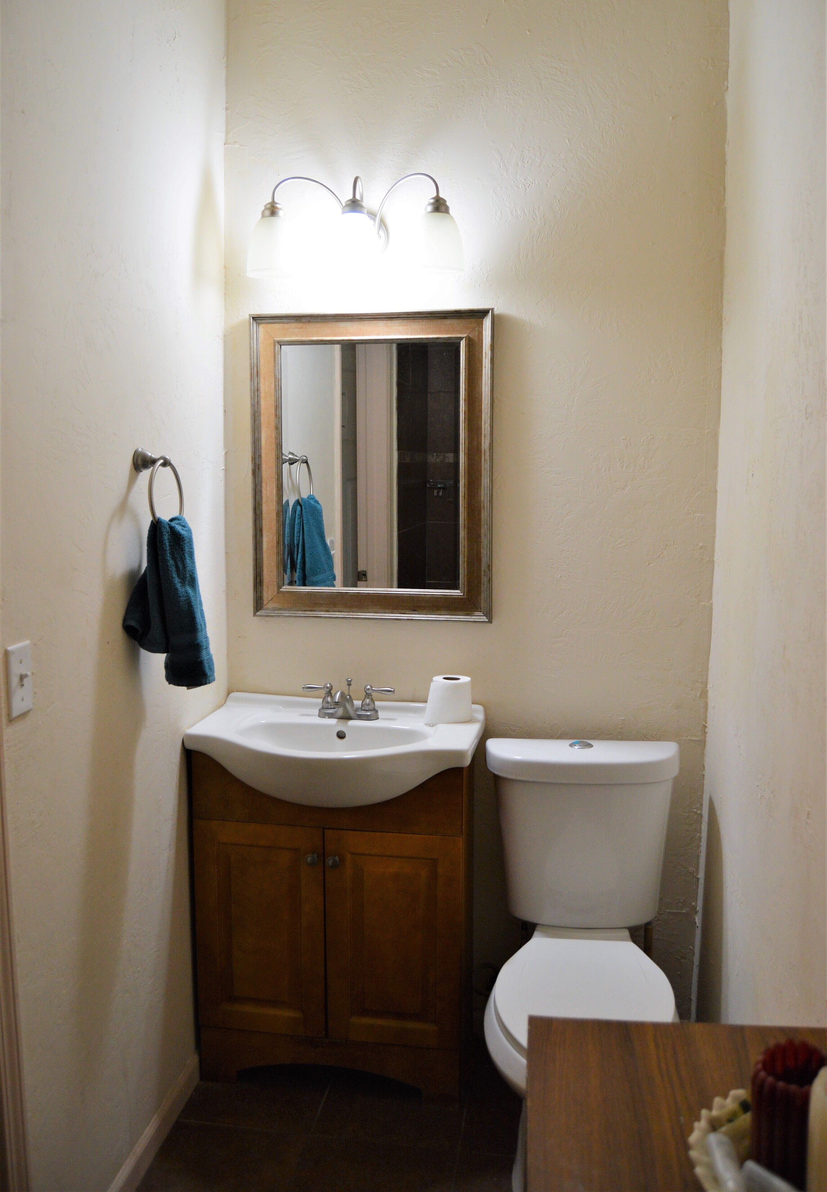A bathroom with a sink, toilet, and a mirror above the sink.