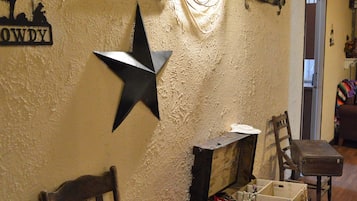 A rustic interior with a star decoration, a wooden chair, a skull, and a planter with red foliage.