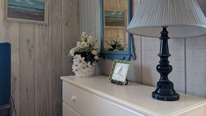 A dresser with a lamp, a mirror, and a framed picture. - Lakefront Cottage w/Breathtaking Views! Hiking.PaddleBoat.Doc.Fishing.WiFi (Wells)