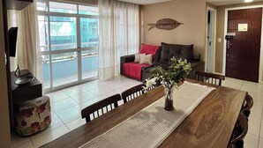 A modern living room with a dining table, sofa, and ceiling fan. - Family apartments - air conditioning, fan, internet... fully furnished. (Arraial do Cabo)