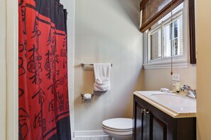 Een bad/douchecombinatie, een haardroger, handdoeken, zeep