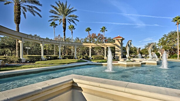 A pool area with a pergola labeled "Emerald Isle," palm trees, and a fountain. - 5 Mi to Disney: Emerald Island Resort Condo! (Kissimmee)