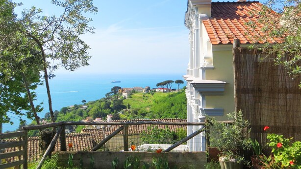A coastal view with a traditional building featuring a tiled roof and a balcony. - A full immersion in paradise (Vietri sul Mare)