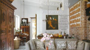 A cozy living room with a sofa, a vase with flowers, and a table with a plate of food. - A full immersion in paradise (Vietri sul Mare)