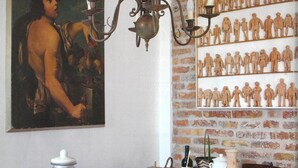 A dining table with pumpkins, a wine bottle, and a wall with a brick pattern. - A full immersion in paradise (Vietri sul Mare)