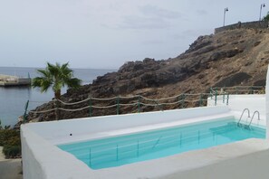 A pool with a clear view of the sea and rocky terrain. - Apartment in traditional fishing port, quiet area, close to the beach (Puerto del Carmen)