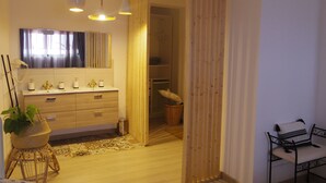 Un baño moderno con tocador de madera, un espejo e iluminación colgante.