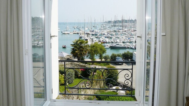 Une vue depuis un balcon doté d’une balustrade, donnant sur une marina remplie de bateaux.