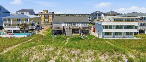 A coastal residential area with multiple two-story houses, a swimming pool, and a sandy beach.