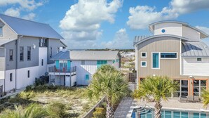 A coastal property with multiple buildings, a swimming pool, and a view of the ocean.