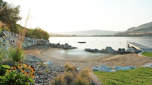 Vista sul lago con un pontile, rocce e una barca.