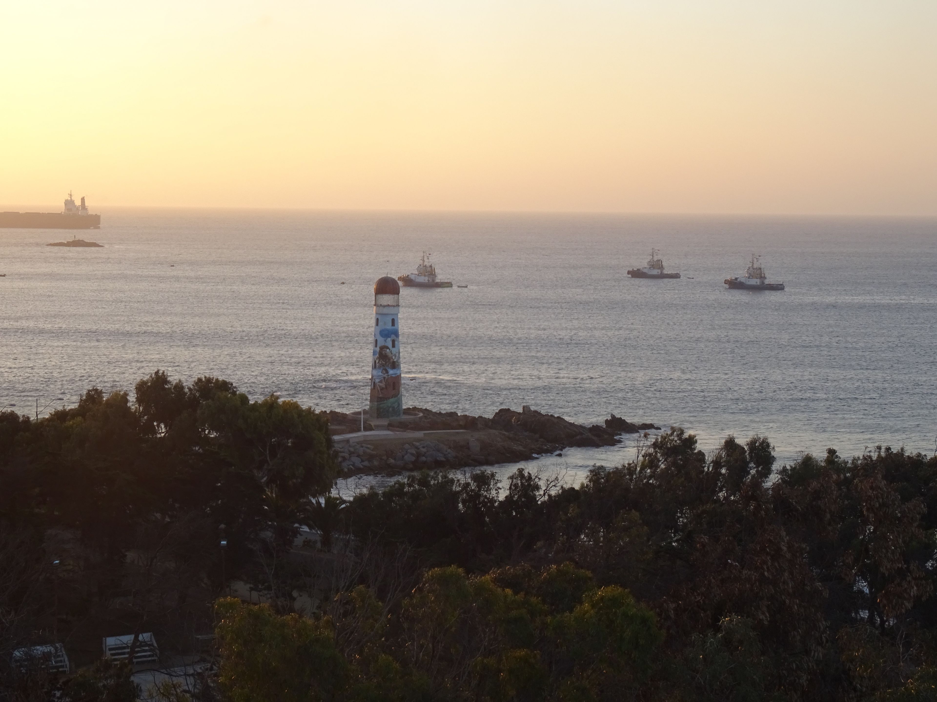 Un far a una roca amb el mar al fons.