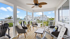 A covered outdoor area with wicker furniture, a ceiling fan, and a view of the ocean and houses. - Lone Star - Updated Gulf-View Home in Gulf Trace of Grayton Beach, Private Pool! (Gulf Trace)