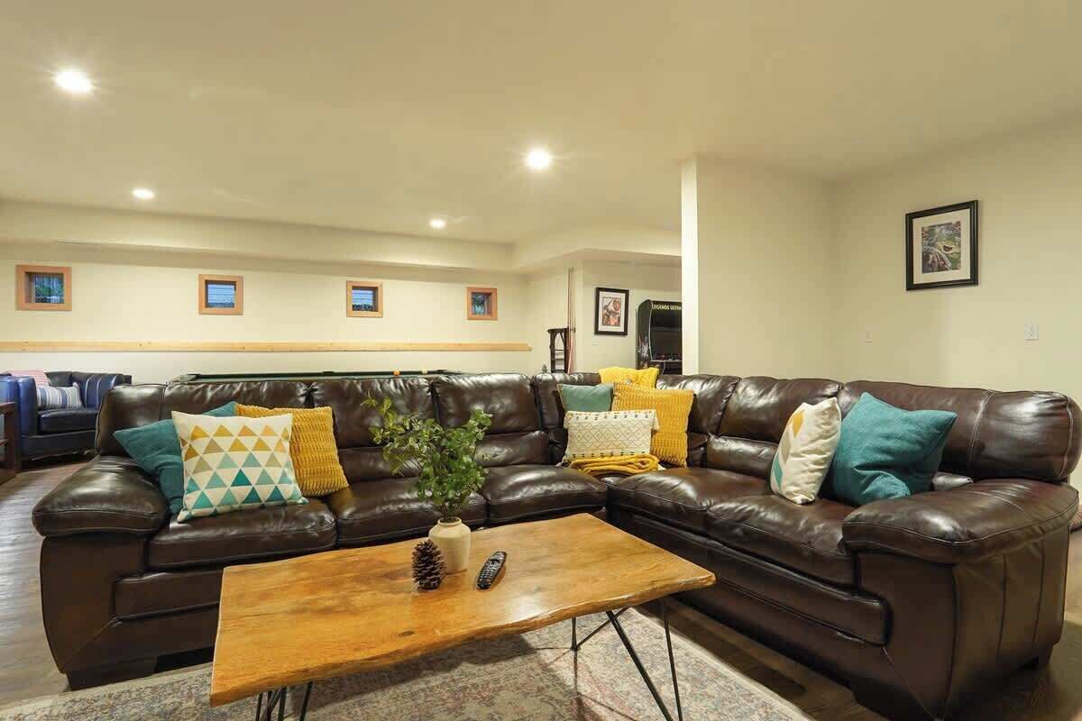 A living room with a brown leather sofa, a wooden coffee table, and a small plant.