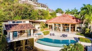 A modern resort with a swimming pool, outdoor seating, and lush greenery.