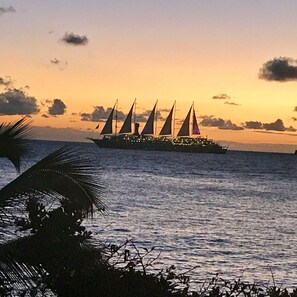 Un gran crucero con numerosas velas fondeado en aguas tranquilas durante el atardecer.