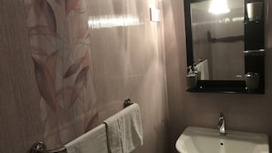 A bathroom with a white sink, a towel hanging on a rack, and a mirror above the sink.
