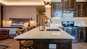 Une cuisine moderne dotée d’un îlot central, d’appareils électroménagers en acier inoxydable et de meubles de rangement en bois.