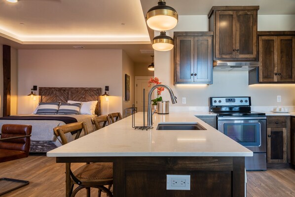 A modern kitchen with a central island, stainless steel appliances, and wooden cabinets.