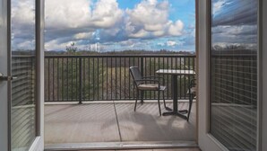 A balcony with a table and chairs, a view of the sky and clouds, and a fence. - Unit 2507 - FREE Attraction Ticket with EACH night Stay Including Dollywood (Pigeon Forge)