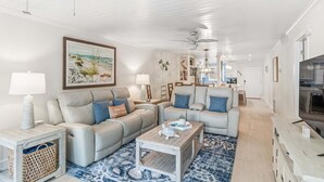 Ein geräumiges Wohnzimmer mit zwei Sofas, einem Couchtisch und einem Fernseher.