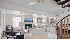 A spacious living room with a fireplace, a television, and a dining area. - GULF VIEWS! 4 Bikes-Across the street from beach ! (Santa Rosa Beach)
