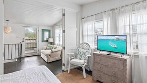 A room with a bed, a television, a chair, a dresser, and a balcony. - GULF VIEWS! 4 Bikes-Across the street from beach ! (Santa Rosa Beach)