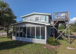 A house with a covered porch, a small deck, and a windowed front section.