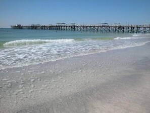 A beach with a wooden pier extending into the water. -  BEACHFRONT CONDO, GREAT RATES, 1Bdrm UPDATED, CLEAN, FREE BEACH CHAIRS,WIFI,BBQ (Madeira Beach)