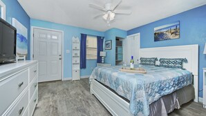 A bedroom with a bed, a dresser, a TV, and a ceiling fan. - QUAINT 1 BDRM!! RECENTLY UPDATED! STEPS ACROSS THE PARKING LOT TO BEACH!! (Fort Walton Beach)