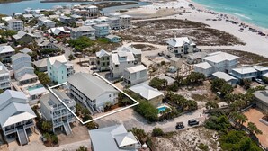 An aerial view of a coastal residential area with multiple houses, a beach, and a clear view of the ocean. - Grayton Beach Villas 103 - Gulf View, Grayton Beach, 30A, Steps to the Sand! (Grayton Beach)