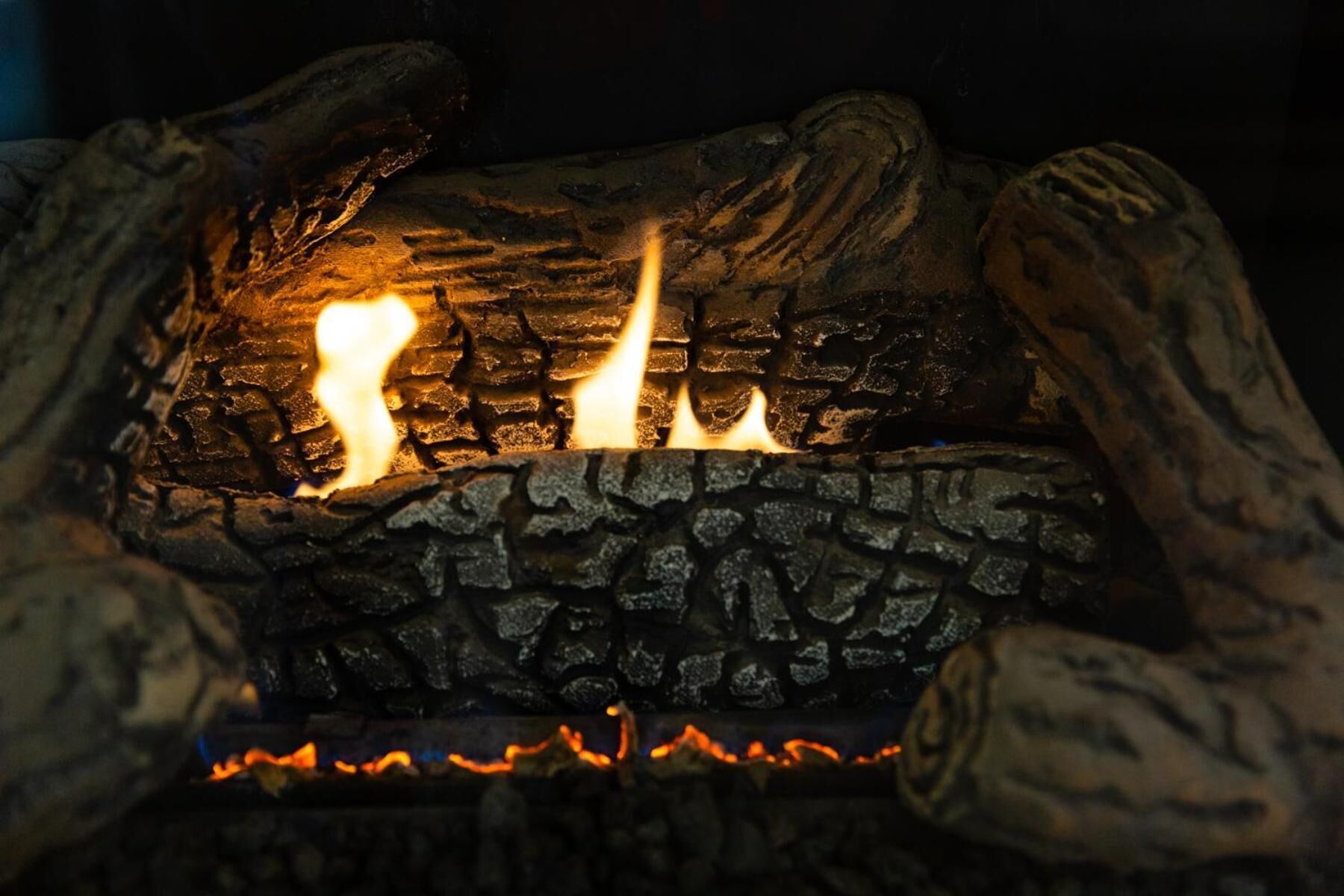 A close-up of a fire burning in a fireplace with logs.