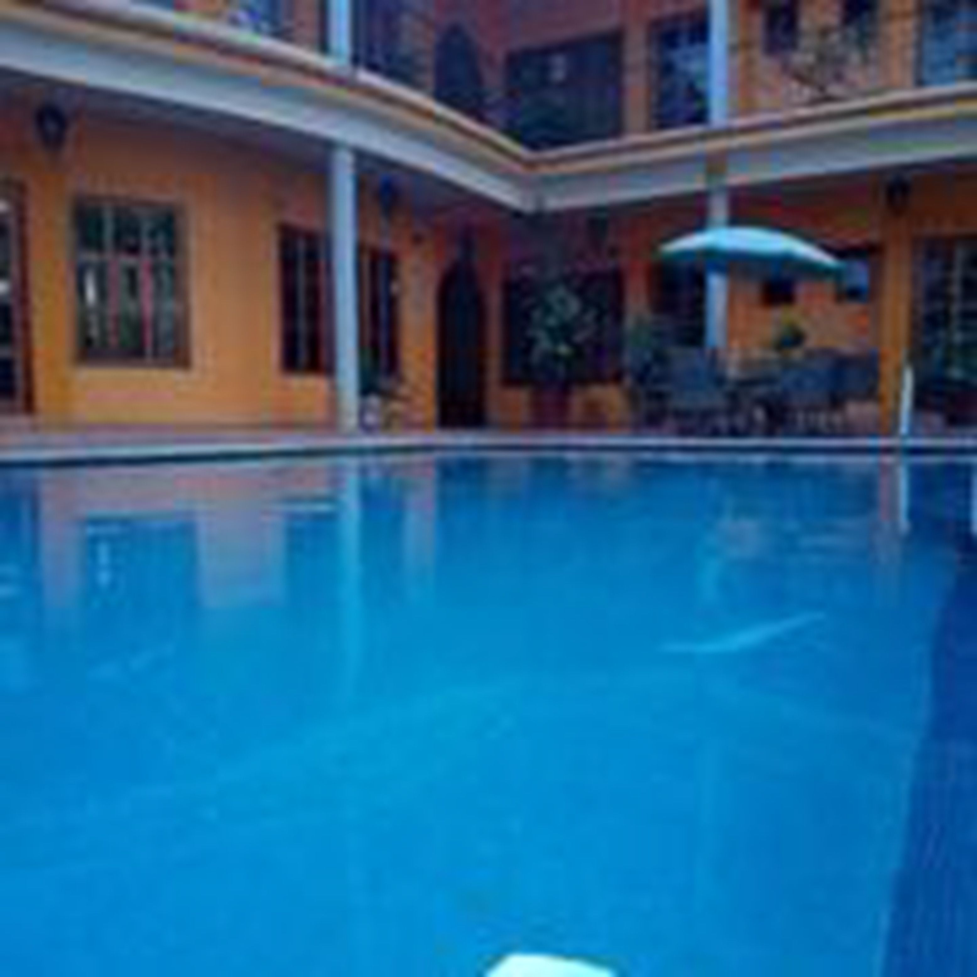 A large indoor swimming pool with a curved balcony and a covered seating area.